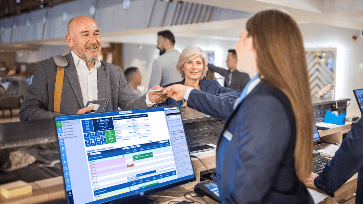 A receptionist checking in a happy guest.